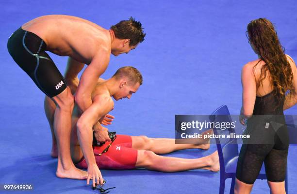 American swimmer Nathan Adrian helps Caeleb Remel Dressel to his feet after the mixed 4 x 100 metre relay race event at the FINA World Championships...