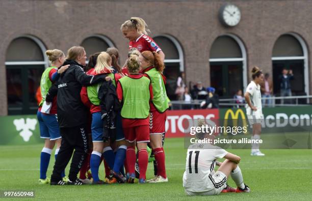 The Danish team celebrates next to Germany's Anja Mittag after the UEFA Women's EURO quarterfinals soccer match between Germany and Denmark at the...