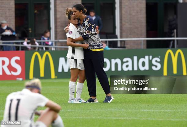 Germany's coach Steffi Jones hugs Lina Magull while Anja Mittag reacts after the UEFA Women's EURO quarterfinals soccer match between Germany and...