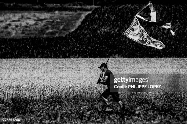 Spectator waves the Scottish flag and the Royal Banner of Scotland along the route during the sixth stage of the 105th edition of the Tour de France...