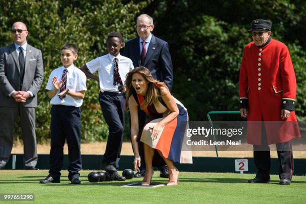 First Lady, Melania Trump, reacts as she tries her hand at bowls whilst meeting British Army veterans, known as Chelsea Pensioners, at Royal Hospital...
