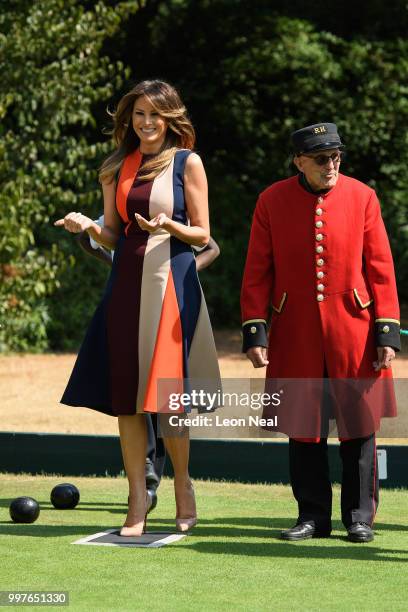 First Lady, Melania Trump, reacts as she tries her hand at bowls whilst meeting British Army veterans, known as Chelsea Pensioners, at Royal Hospital...