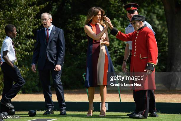 First Lady, Melania Trump, high-fives a Chelsea Pensioner as she tries her hand at bowls as she meets British Army veteransat Royal Hospital Chelsea...