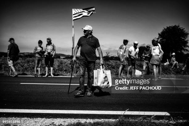 Spectator crosses the race's route during the sixth stage of the 105th edition of the Tour de France cycling race between Brest and Mur-de-Bretagne...