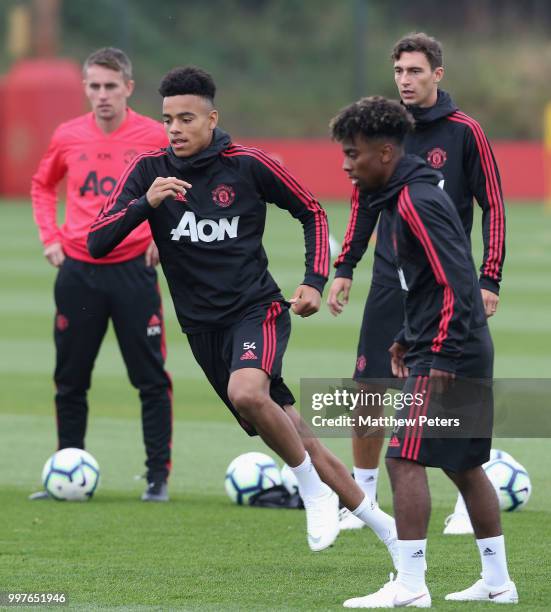 Mason Greenwood, Angel Gomes and Matteo Darmian of Manchester United in action during a first team training session at Aon Training Complex on July...