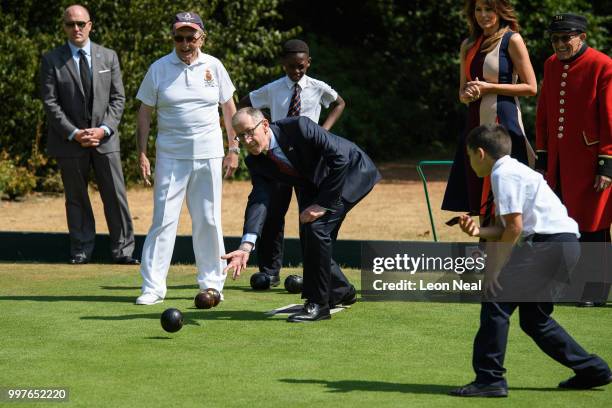 First Lady, Melania Trump, looks on as Philip May, the husband of British Prime Minister Theresa May, tries bowls as she meets British Army veterans...