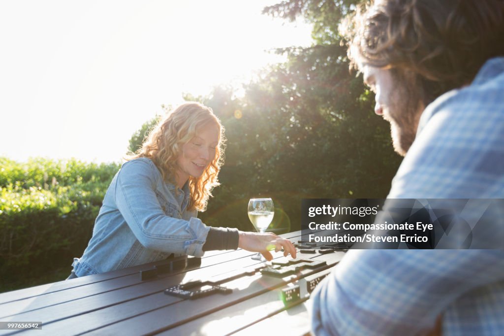 Couple playing dominoes at campsite picnic table