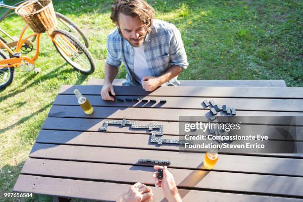 couple playing dominoes at campsite picnic table - "compassionate eye" fotografías e imágenes de stock