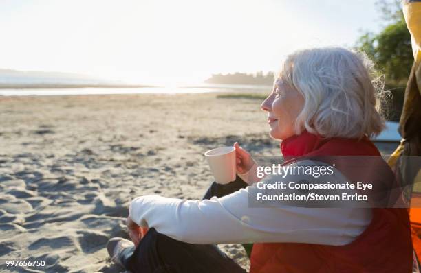 senior woman camping on beach looking at ocean view - cef - fotografias e filmes do acervo