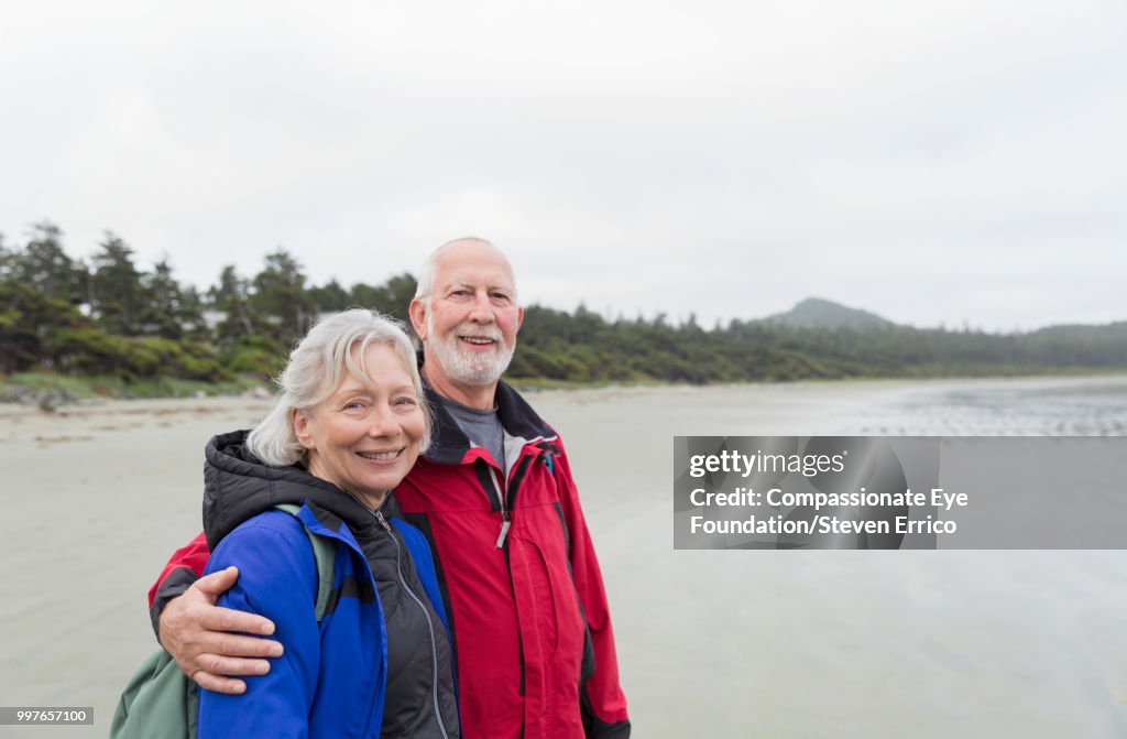 Portrait of senior couple hiking on beach