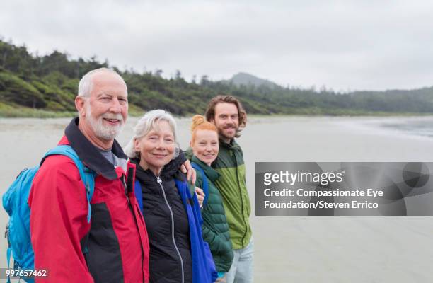 senior couple and adult children hiking on beach looking at ocean view - cef do not delete stock pictures, royalty-free photos & images