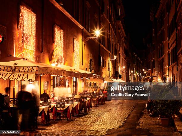 busy street in rome with restaurants at night - yeowell imagens e fotografias de stock