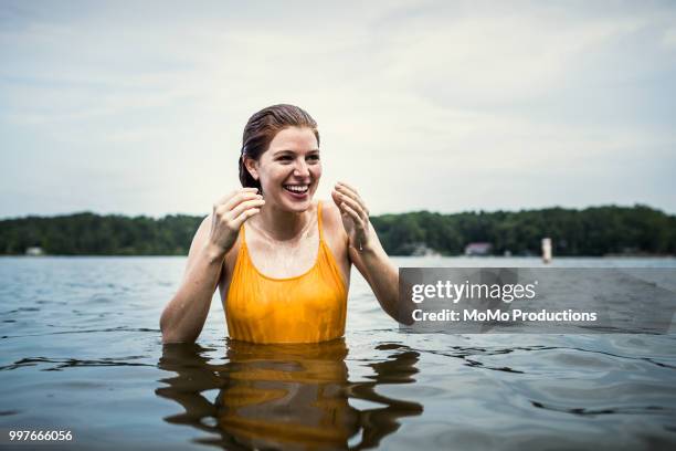 young woman wading in water at lake - standing water stock pictures, royalty-free photos & images