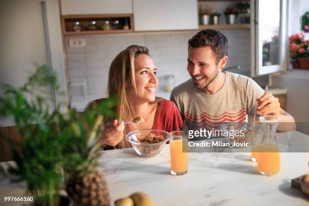 young couple eating together at home - jovic stock pictures, royalty-free photos & images