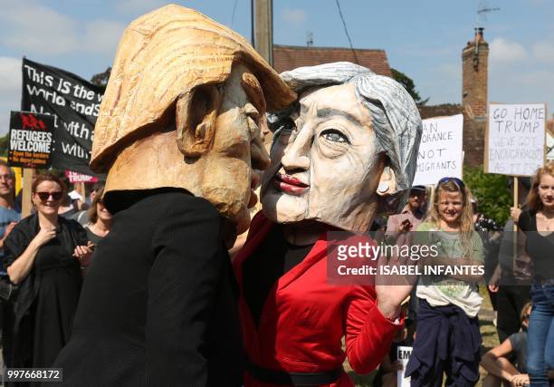 Protesters wearing masks depicting US President Donald Trump and Britain's Prime Minister Theresa May join other protesters against the UK visit of...