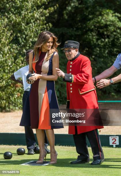 First Lady Melania Trump, center, tries her hand at lawn bowls while speaking to a military pensioner during a visit to The Royal Hospital Chelsea in...