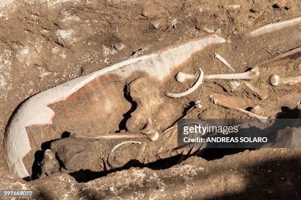 Grave with a skeleton is seen at the archeological site of a Roman building from the Imperial era, I and II century after Christ, near Tiber river at...