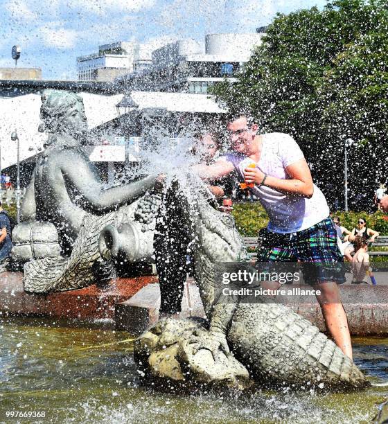 Participants of a water fight at and in the Neptune Fountain enjoy the hot weather in Berlin, Germany, 30 July 2017. The event was organised via...