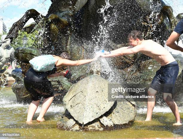 Participants of a water fight at and in the Neptune Fountain enjoy the hot weather in Berlin, Germany, 30 July 2017. The event was organised via...