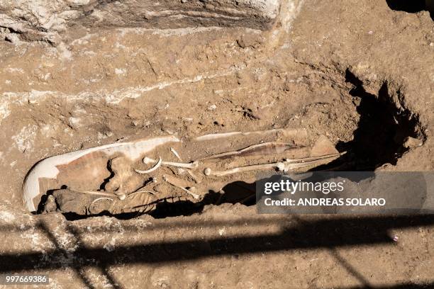 Grave with a skeleton is seen in the archeological site of a Roman building from the Imperial era, I and II century after Christ, near Tiber river at...