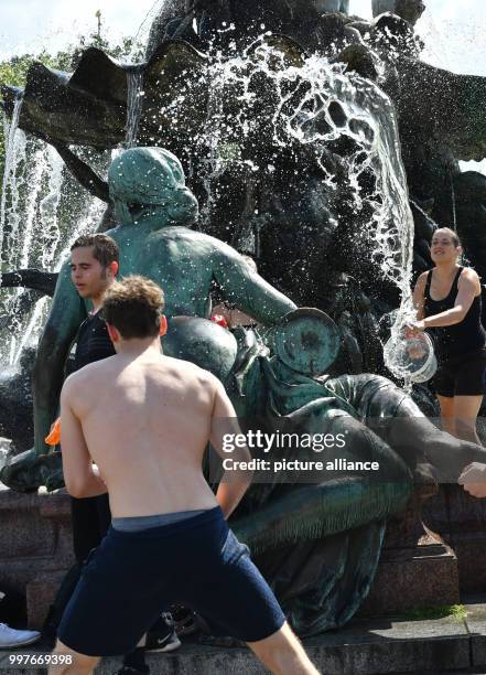 Participants of a water fight at and in the Neptune Fountain enjoy the hot weather in Berlin, Germany, 30 July 2017. The event was organised via...