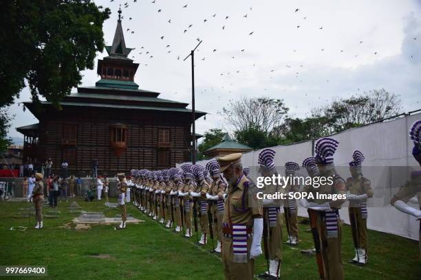 Jammu and Kashmir policemen present a guard of honor at Martyr's graveyard in Srinagar. July 13 is observed as Martyrs' Day in memory of the day when...