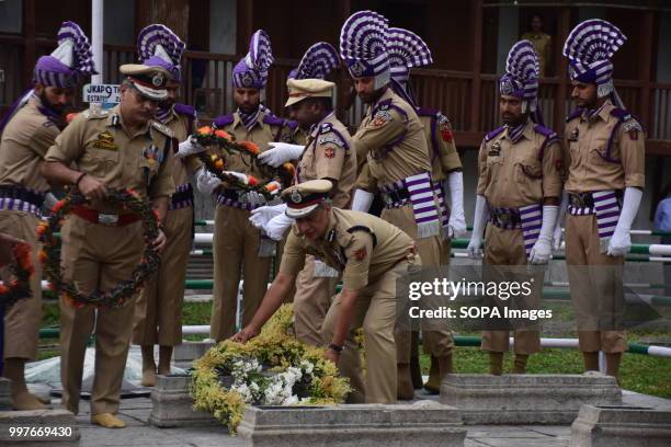 Jammu and Kashmir policemen putting wreath on a grave at Martyr's Graveyard in Srinagar. July 13 is observed as Martyrs' Day in memory of the day...