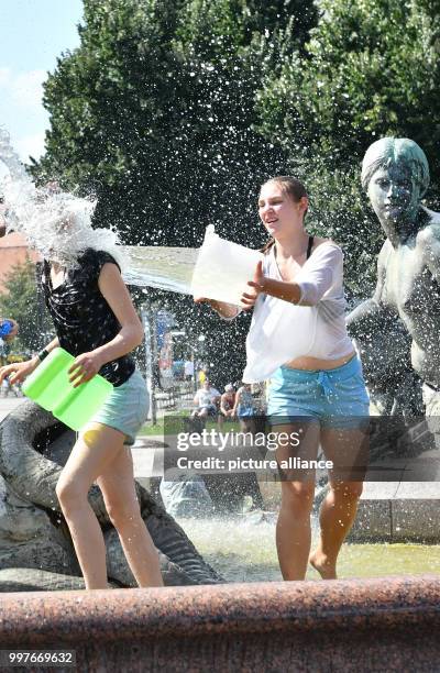 Participants of a water fight at and in the Neptune Fountain enjoy the hot weather in Berlin, Germany, 30 July 2017. The event was organised via...