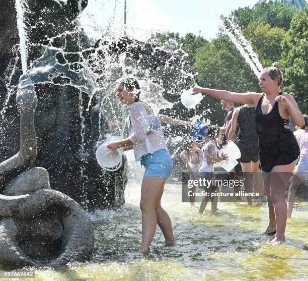 Participants of a water fight at and in the Neptune Fountain enjoy the hot weather in Berlin, Germany, 30 July 2017. The event was organised via...