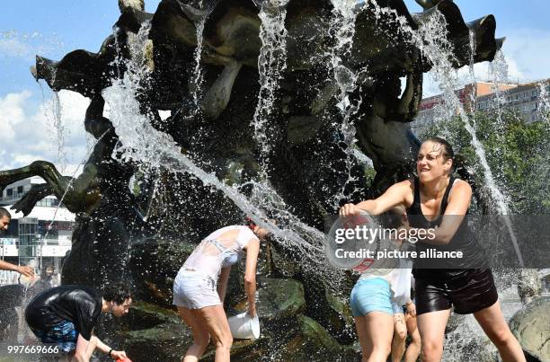 Participants of a water fight at and in the Neptune Fountain enjoy the hot weather in Berlin, Germany, 30 July 2017. The event was organised via...