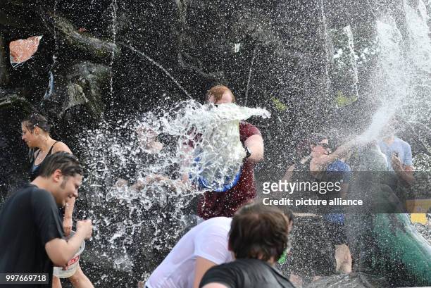 Participants of a water fight at and in the Neptune Fountain enjoy the hot weather in Berlin, Germany, 30 July 2017. The event was organised via...