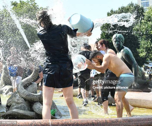 Participants of a water fight at and in the Neptune Fountain enjoy the hot weather in Berlin, Germany, 30 July 2017. The event was organised via...