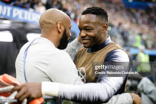 Assistant coach Thierry Henry of Belgium hugs Steve Mandanda of France prior to the 2018 FIFA World Cup Russia Semi Final match between Belgium and...