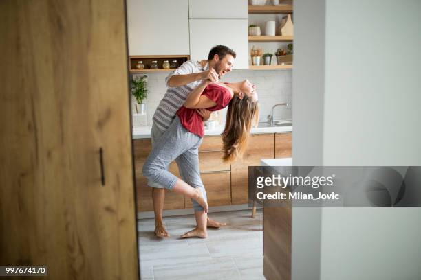 dos amantes bailando en la cocina. - happy couple at home fotografías e imágenes de stock