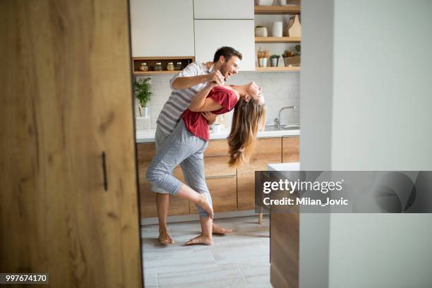two lovers dancing in the kitchen. - falling in love stock pictures, royalty-free photos & images
