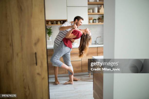 two lovers dancing in the kitchen. - young couple imagens e fotografias de stock