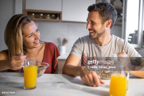 young couple eating together at home - jovic stock pictures, royalty-free photos & images