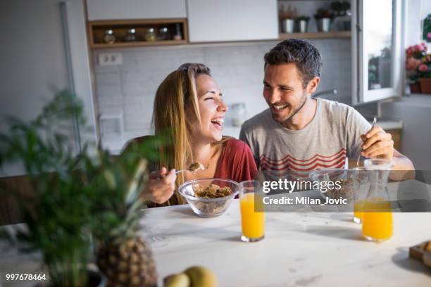 young couple eating together at home - jovic stock pictures, royalty-free photos & images