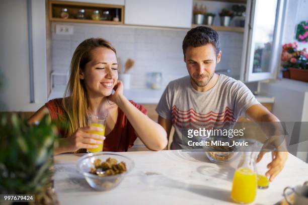 young couple eating together at home - jovic stock pictures, royalty-free photos & images
