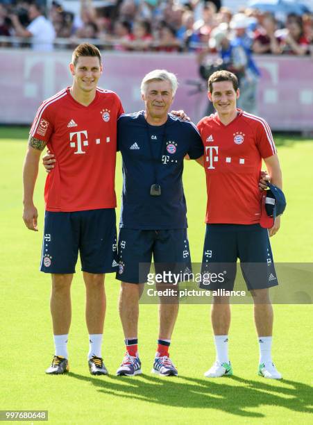 Coach Carlo Ancelotti of Bayern Munich stands between new signings Niklas Suele and Sebastian Rudy at the club's training ground on Saebener Strasse...
