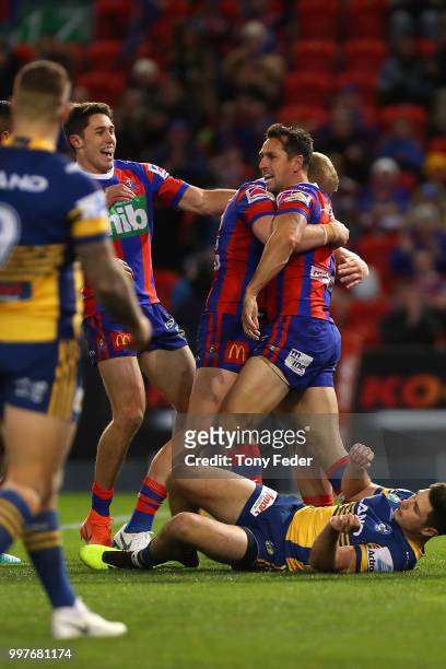 Mitchell Pearce of the Knights celebrates a try with team mates during the round 18 NRL match between the Newcastle Knights and the Parramatta Eels...