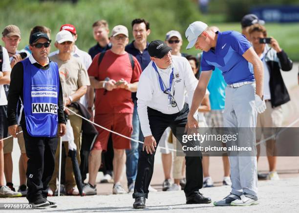 Alexander Knappe of Germany talks with a referee in the 4th round of the men's single competition at the European Tour PGA Championship in Winsen an...