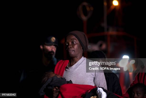 Sub saharan woman holds her baby during the disembark of 107 migrants at the port of Motril. 107 Sub saharan migrants were rescued in Alboran sea by...