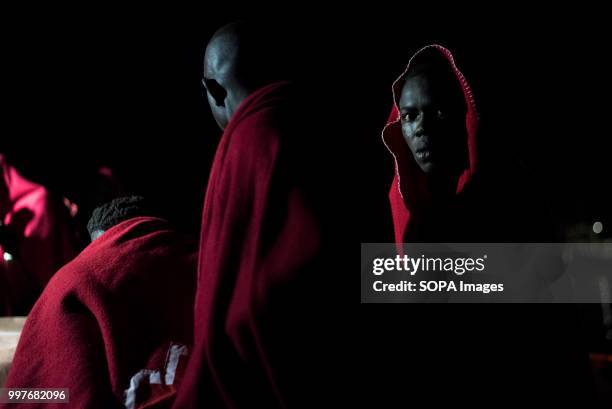 Sub saharan migrants covered with a red Blanket on the Hamal rescue ship before disembark at the port of Motril. 107 Sub saharan migrants were...
