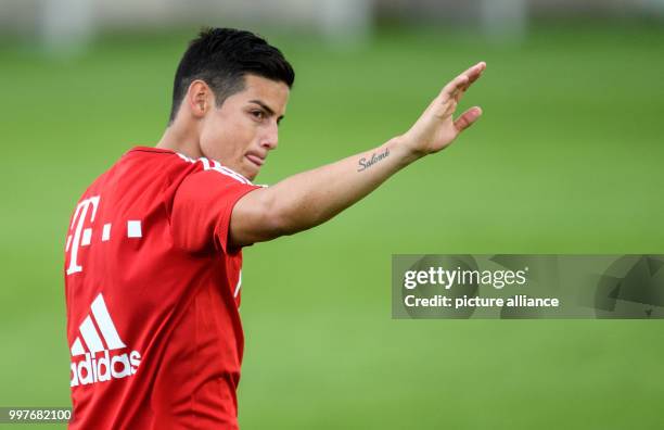 James Rodriguez of Bayern Munich greets the fans watching the training session at the club's training ground on Saebener Strasse in Munich, Germany,...