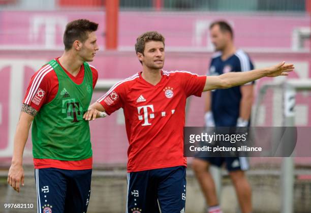 Bayern Munich new signing Niklas Suele speaking with BAyern Munich's Thomas Mueller at the club's training ground on Saebener Strasse in Munich,...
