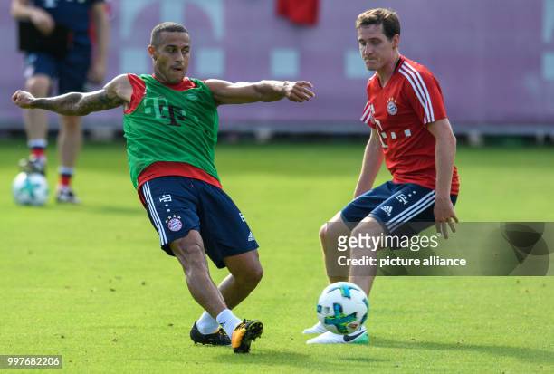 Bayern Munich's Thiago and new signing Sebastian Rudy vie for the ball during a training session at the club's training ground on Saebener Strasse in...