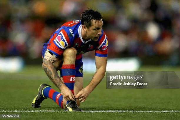 Mitchell Pearce of the Knights ties up his shoe laces during the round 18 NRL match between the Newcastle Knights and the Parramatta Eels at McDonald...