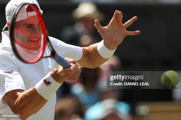 Player John Isner returns against South Africa's Kevin Anderson during their men's singles semi-final match on the eleventh day of the 2018 Wimbledon...