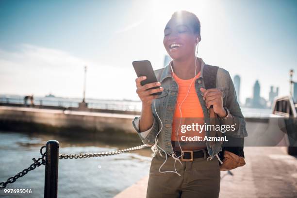 若い女性の携帯電話を保持していると、音楽を聴くこと - azmanl ストックフォトと��画像